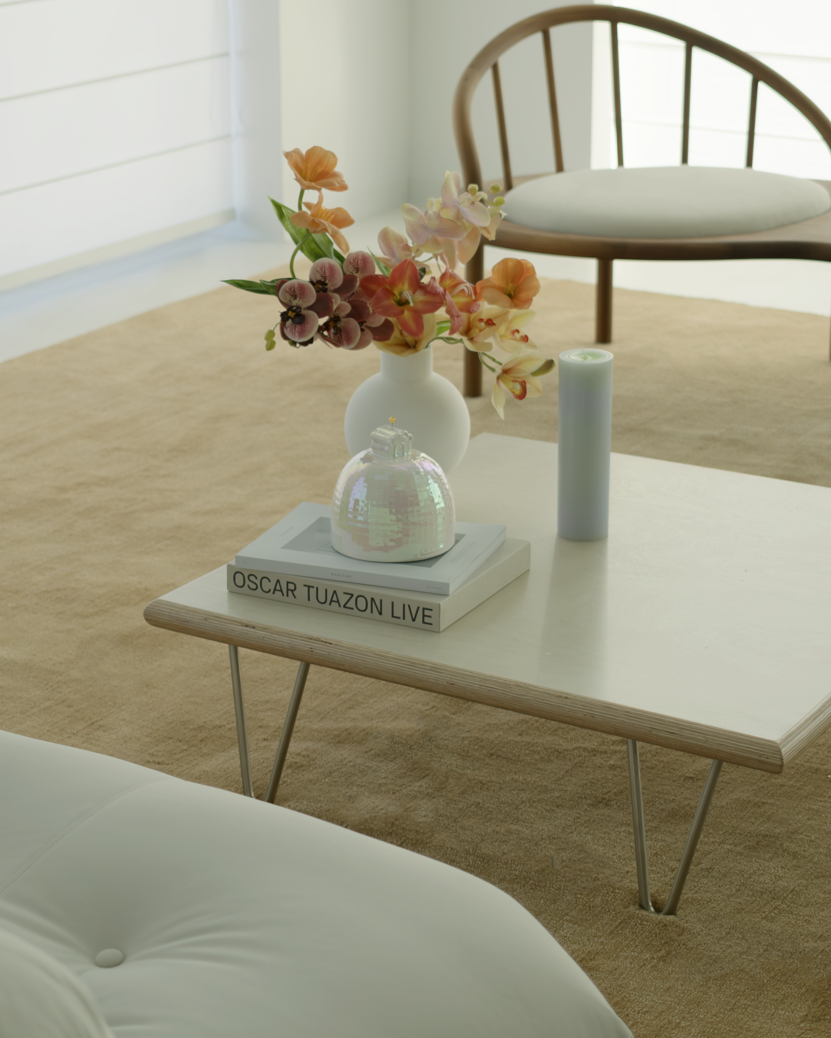 Coffee table with decorative items including a pet urn of flowers, a book, and a candle in a minimalistic living room.